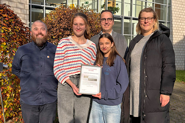 Foto: Regionalkoordinatorin Marijke Garretsen überreicht uns unsere Urkunde zum 20-jährigen Jubiläum „Schule ohne Rassismus – Schule mit Courage“.