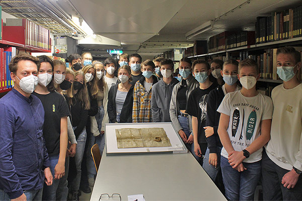 Foto: Die Klasse 9b wirft einen Blick auf die Urkunde mit der ersten Erwähnung der Stadt Selm aus dem Jahr 858.